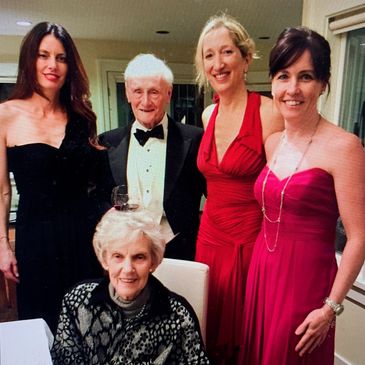 Group of five elegantly dressed people at an indoor event.