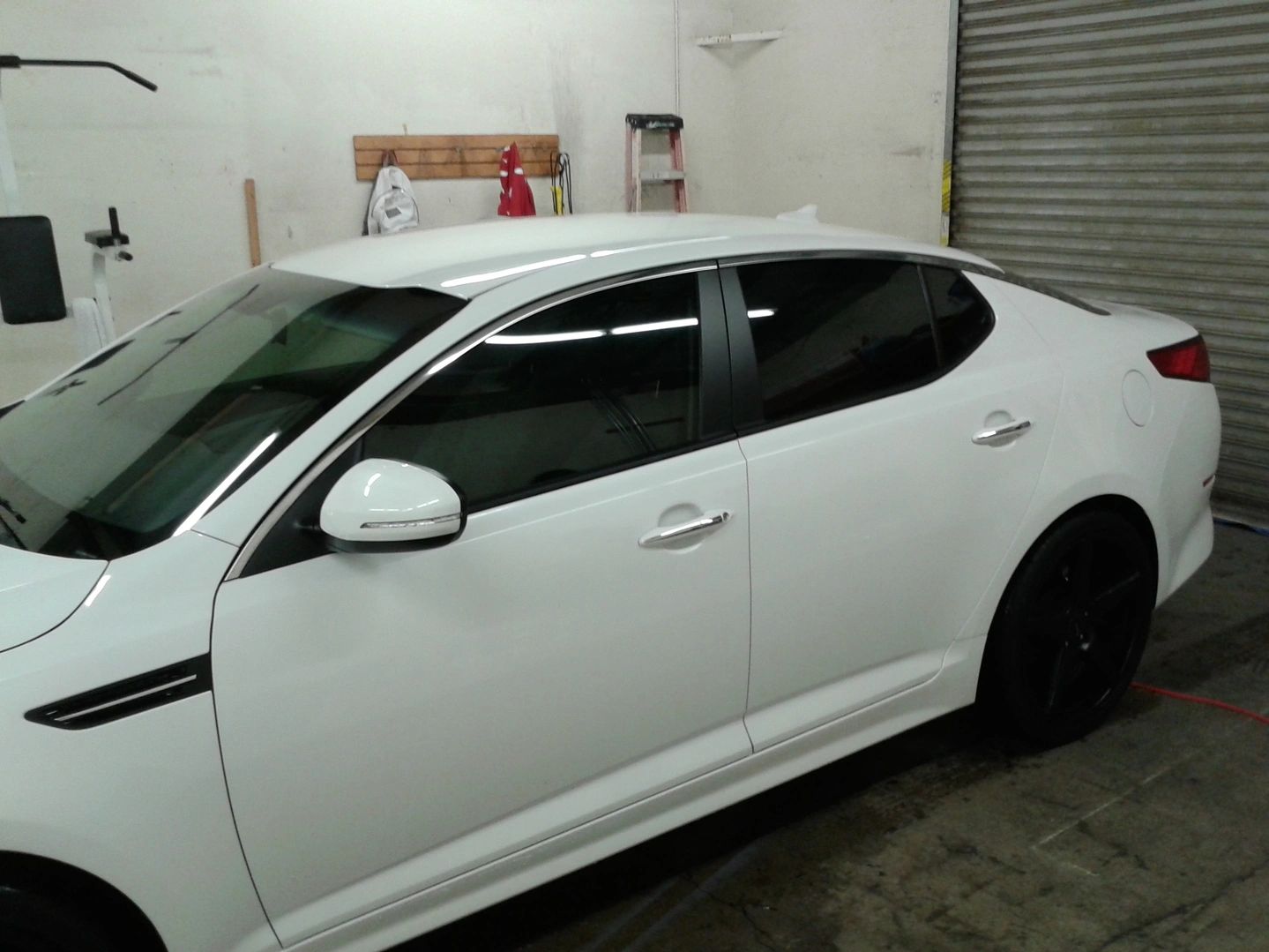 White car with tinted windows parked indoors.