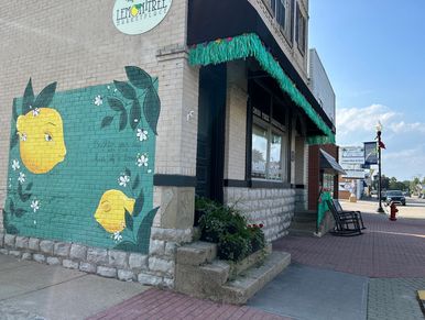 Mural of lemons on a building corner with a sign for Lemon Tree Cafe.