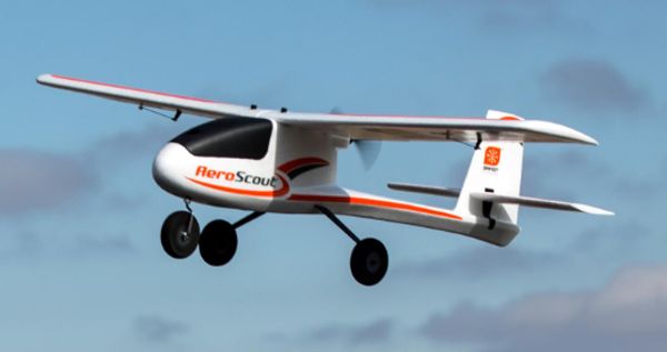 Small white drone aircraft flying against a blue sky.