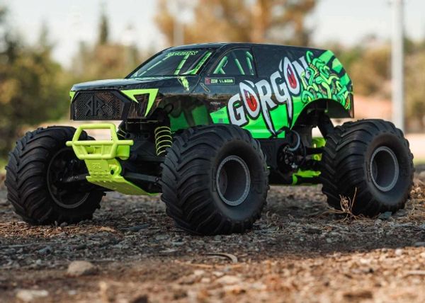 Green and black remote control monster truck on dirt.
