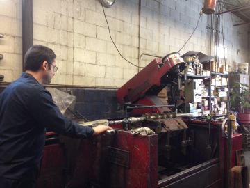 Man operating machinery in an industrial workshop.