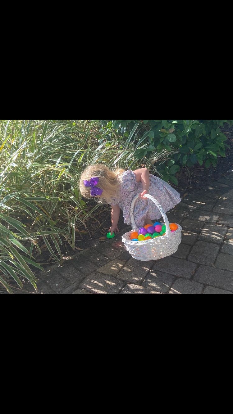 Girl finding Easter eggs near the bushes