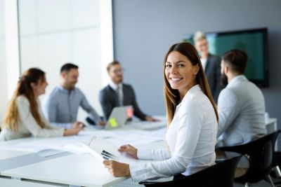 Smiling businesswoman at office meeting.