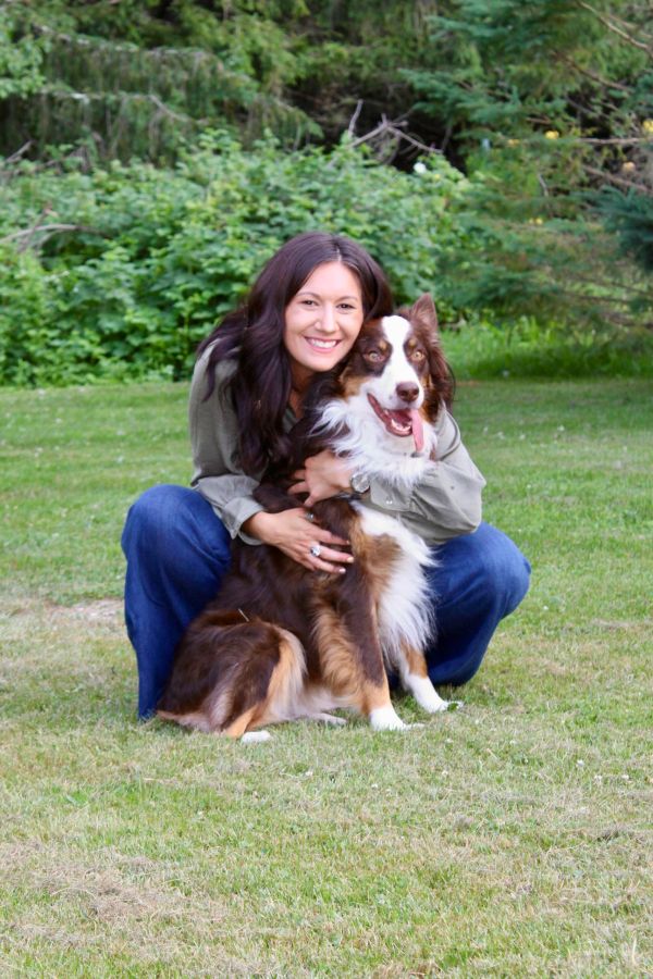Woman hugging her happy dog outdoors.