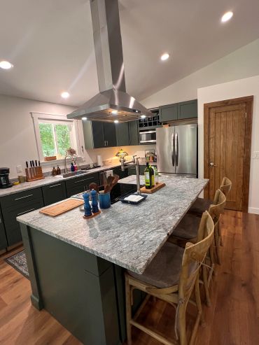 Modern kitchen with a large island and wooden stools.