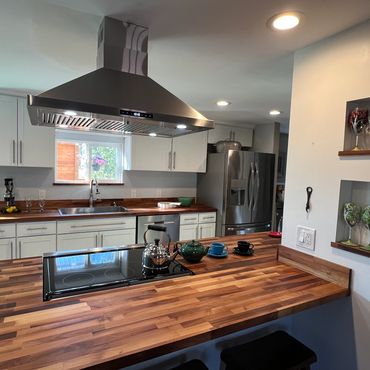 Modern kitchen with wooden countertops and stainless steel appliances.