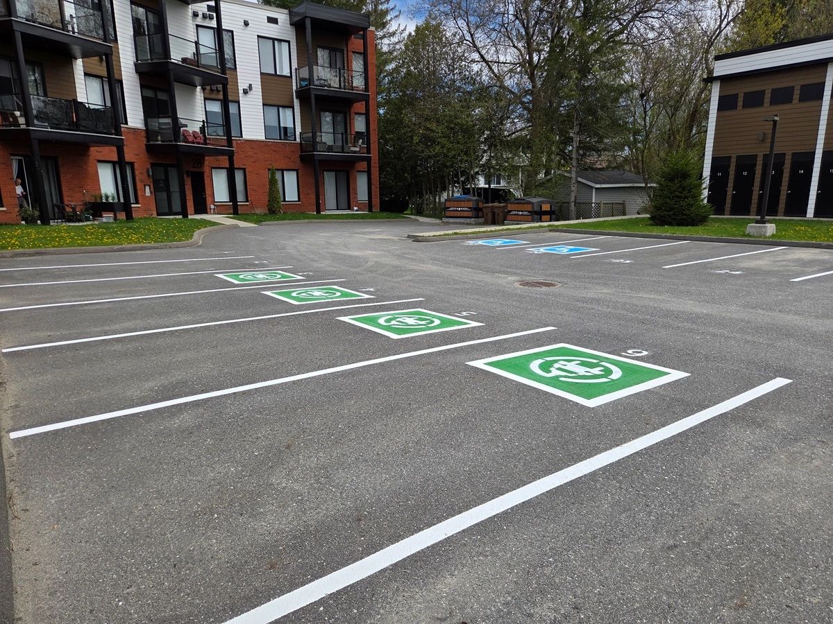 Places de parking réservées aux voitures électriques devant un immeuble.