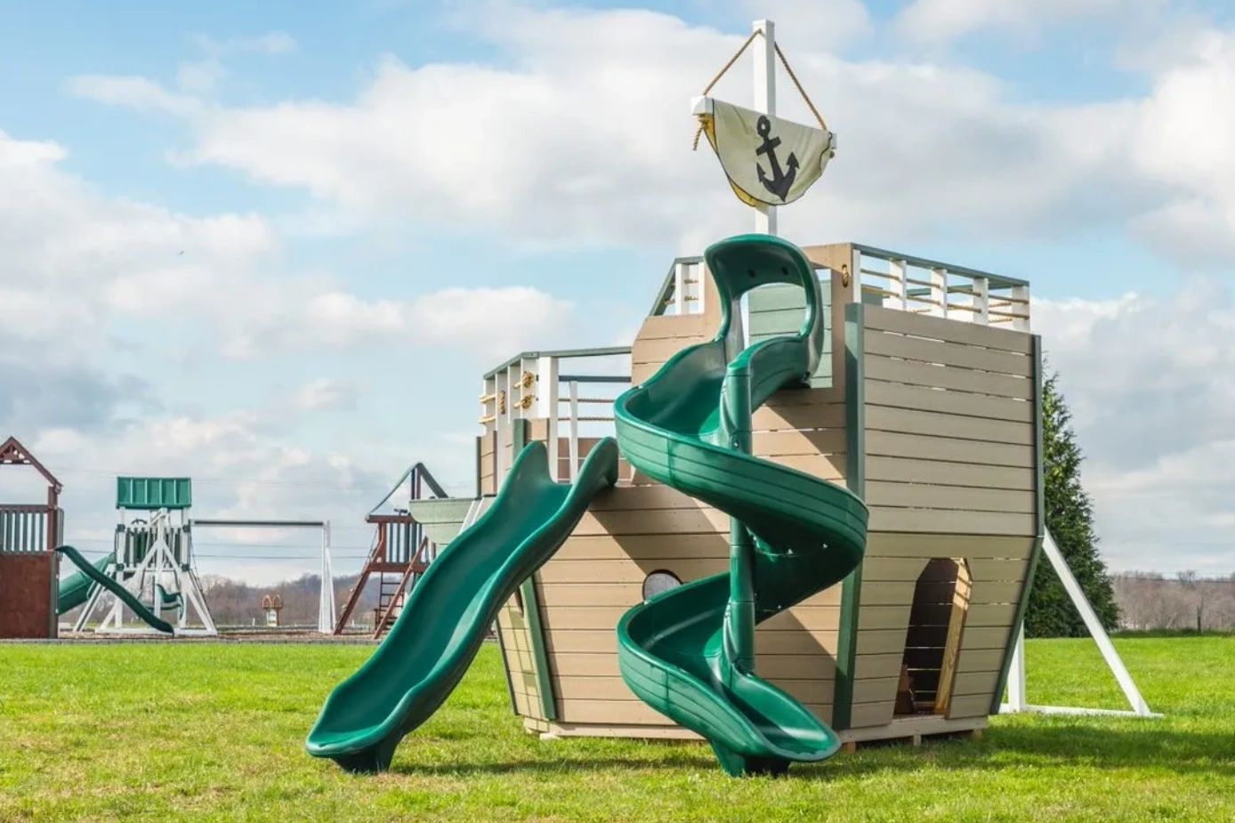 vinyl pirate ship playset with swings, sliding boards on beach setting.