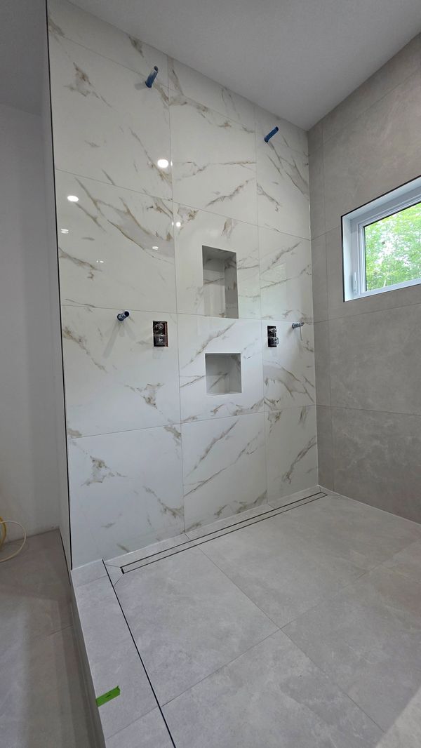 Douche moderne carrelée avec fenêtres et niches.