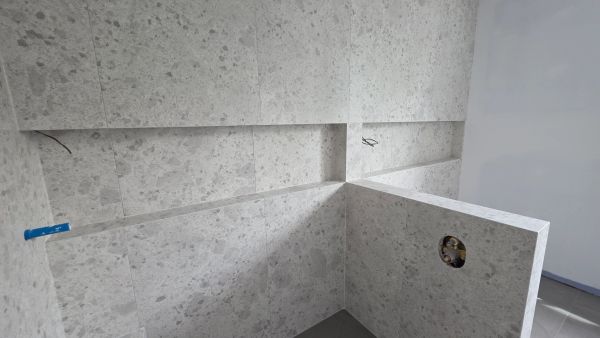 Mur de salle de bain en pierre à mi-installation.