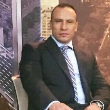 Hombre con traje formal sentado.