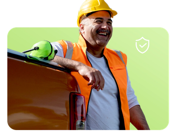 Smiling construction worker leaning on a truck.