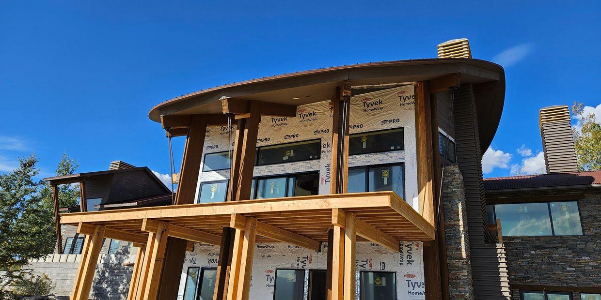 Exterior Picture of a Home Under Construction with siding removed and framing visable. 