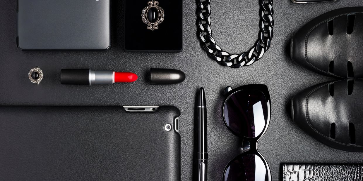 Collection of black and red fashion accessories arranged neatly.