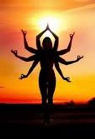 Silhouette of a person with multiple arms posed in yoga against a vibrant sunset.