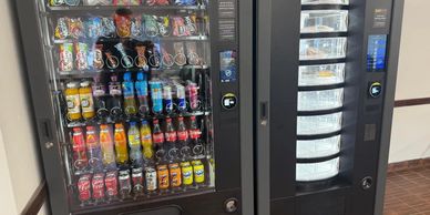 Two vending machines side by side, one with snacks and drinks, the other with fresh food.