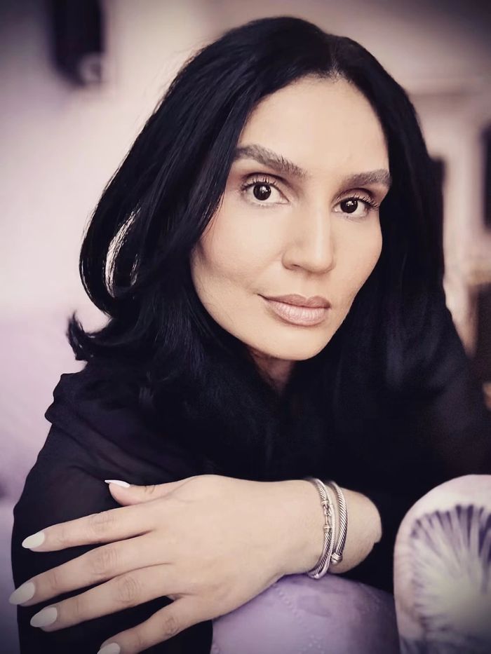 Close-up portrait of a woman with dark hair and bracelets.