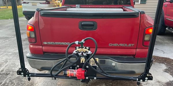 Rear view of a red Chevrolet Silverado with a mounted sprayer system.