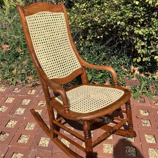 Wooden rocking chair with woven seat and backrest.