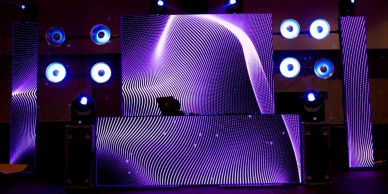 Escenario con luces y pantallas LED violetas.