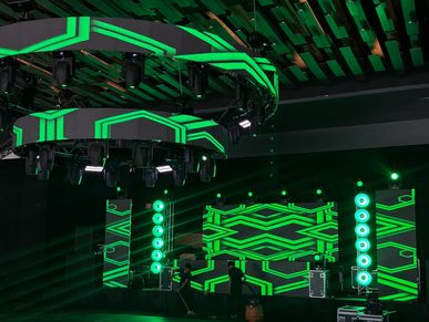 Futuristic green LED light setup on a ceiling structure in a dark room.