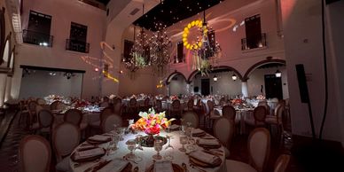 Elegant banquet hall with round tables and floral centerpieces.