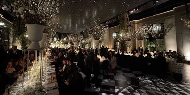 Elegant indoor banquet with floral decorations and starry ceiling ambiance.