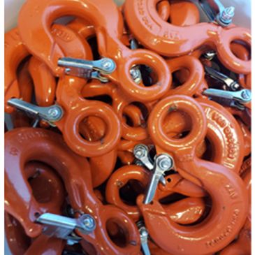 Bright orange metal hooks with clamps piled together.