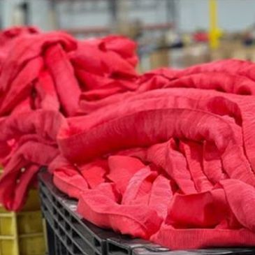 Bright red fabric rolls in a textile factory.