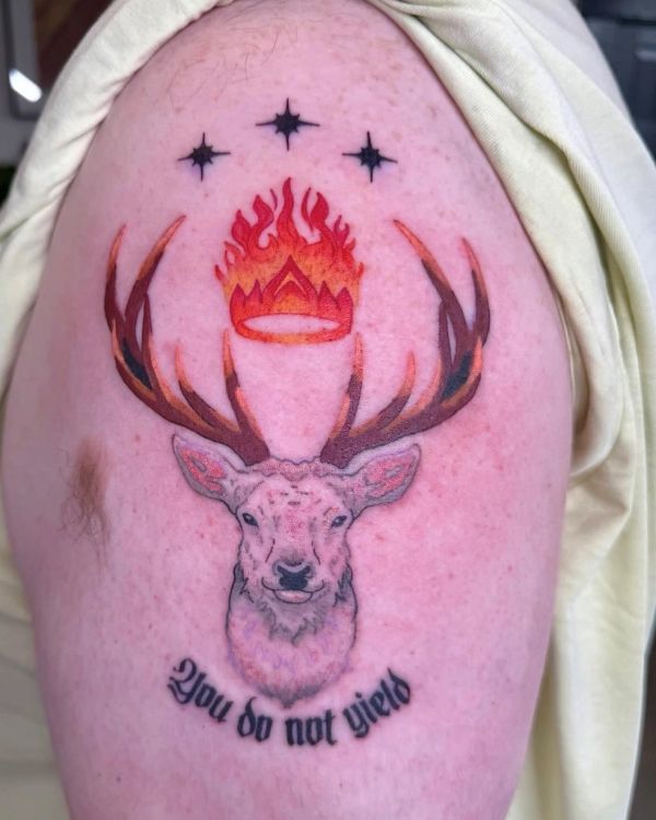 Tattoo of a deer with a flaming crown and stars, text reads 'You do not yield'