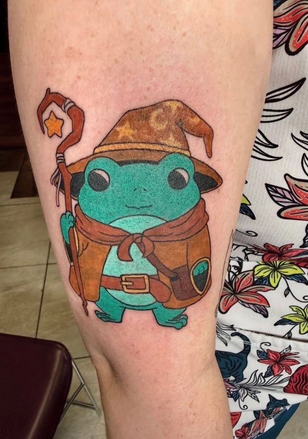 Tattoo of a frog wizard holding a staff with star.