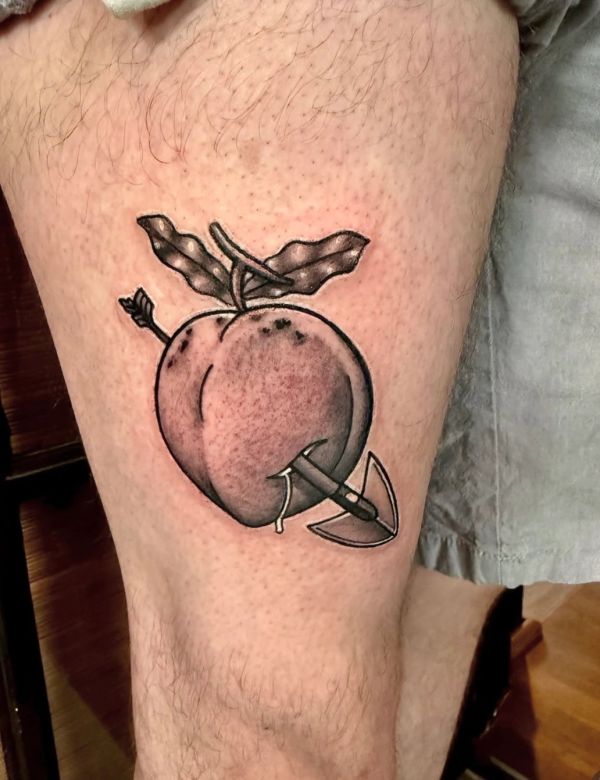 Tattoo of a peach pierced by an arrow on a hairy leg.