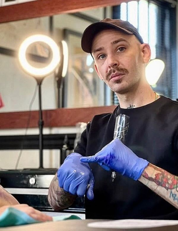 Tattoo artist preparing gloves and equipment.