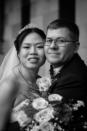 Black and white photo of a bride and groom embracing on their wedding day.
