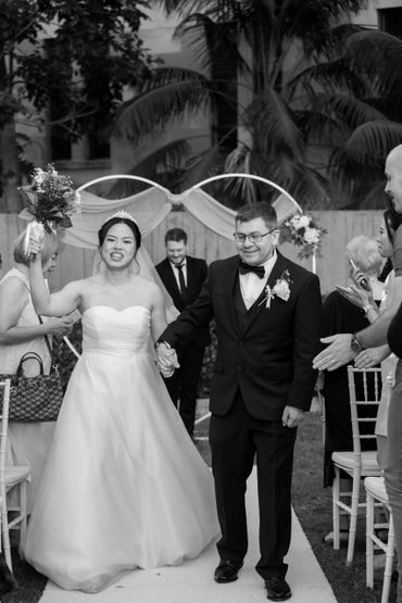 Bride and groom joyfully walking down the aisle after their wedding ceremony.
