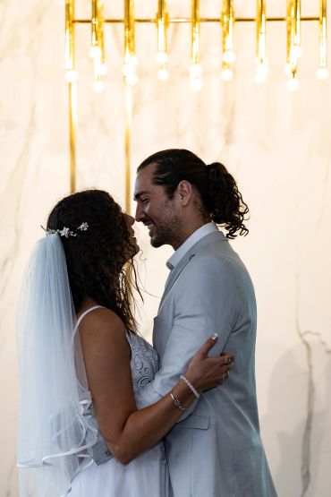 Bride and groom lovingly embrace during wedding ceremony.