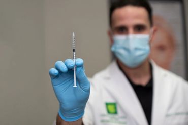 Healthcare worker holding a syringe with a vaccine.