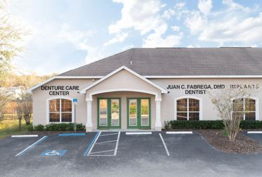 Exterior of a dental care center with parking spaces and clear signage.