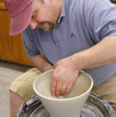 Thomas Hooper, owner and resident artist of Artyard Studio, shaping clay on pottery wheel.