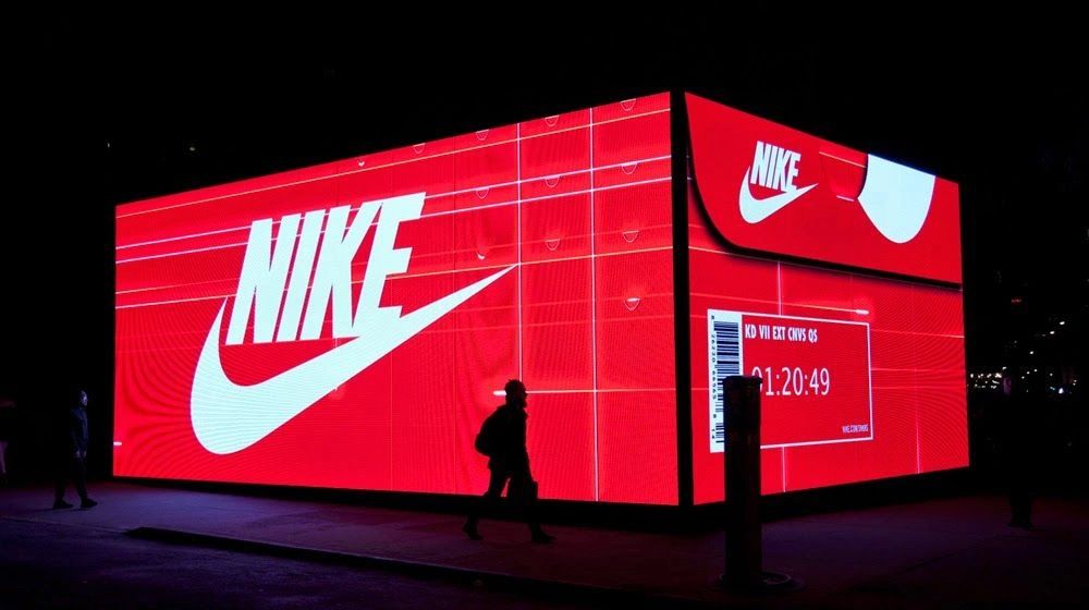 Nike illuminated pop-up shop with large red display, featuring the Nike logo and countdown timer, showcasing guerrilla marketing strategy.