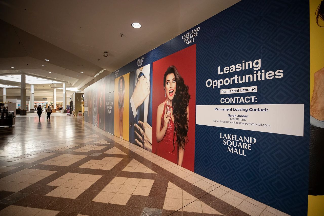 Mall advertising guarantees increased exposure and enhances brand awareness, capturing the attention of potential customers and establishing a strong presence in shoppers' minds. Mall advertising wall featuring leasing opportunities at Lakeland Square Mall, showcasing vibrant images of models and promotional text, emphasizing business growth and brand visibility in high-traffic retail environments.