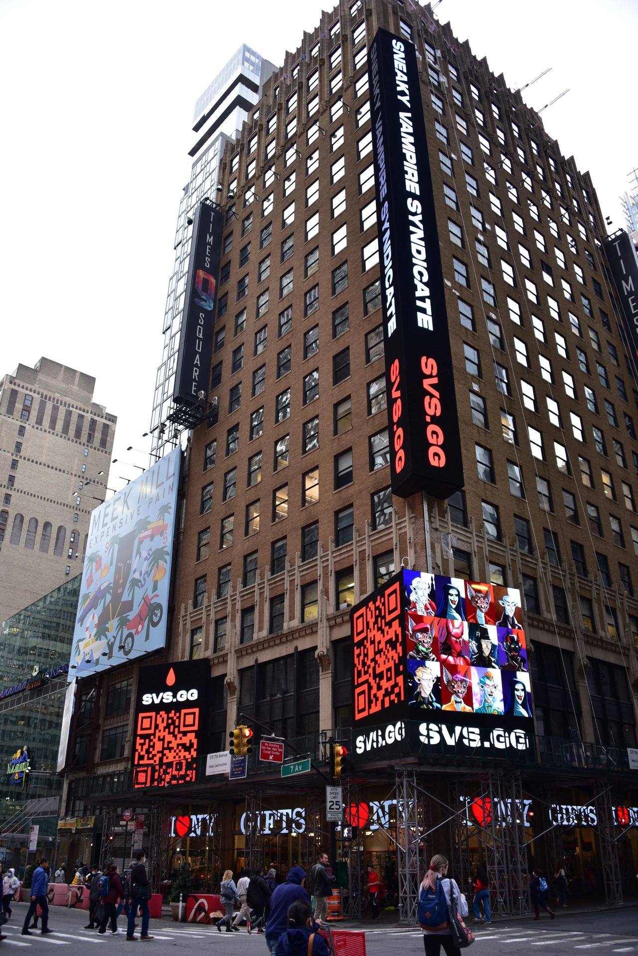 Billboards in Times Square featuring "Sneaky Vampire Syndicate" and "Meek Mill: Expensive Pain," showcasing vibrant visuals and QR code for audience engagement.