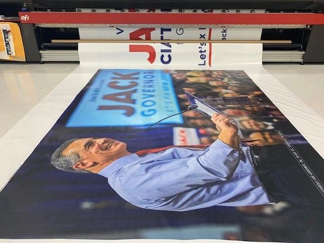 Political campaign banner featuring a candidate named Jack, delivering a speech at a rally, emphasizing the importance of political advertising in influencing voter preferences.