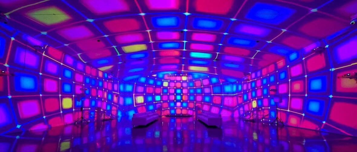 Colorful projection mapping display on walls creating an immersive atmosphere, enhancing advertising experiences in marketing environments.