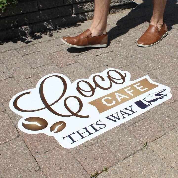 Sidewalk Decals is a clean method of distributing information. Sidewalk stencil directing foot traffic to "Coco Cafe" with a playful design, featuring coffee icons and the phrase "THIS WAY," highlighting innovative sidewalk media strategies.