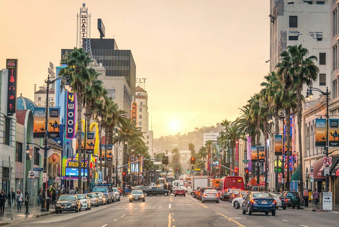 Vibrant street scene in Los Angeles with palm trees, billboards, and traffic, showcasing the competitive advertising landscape and iconic culture of the city.