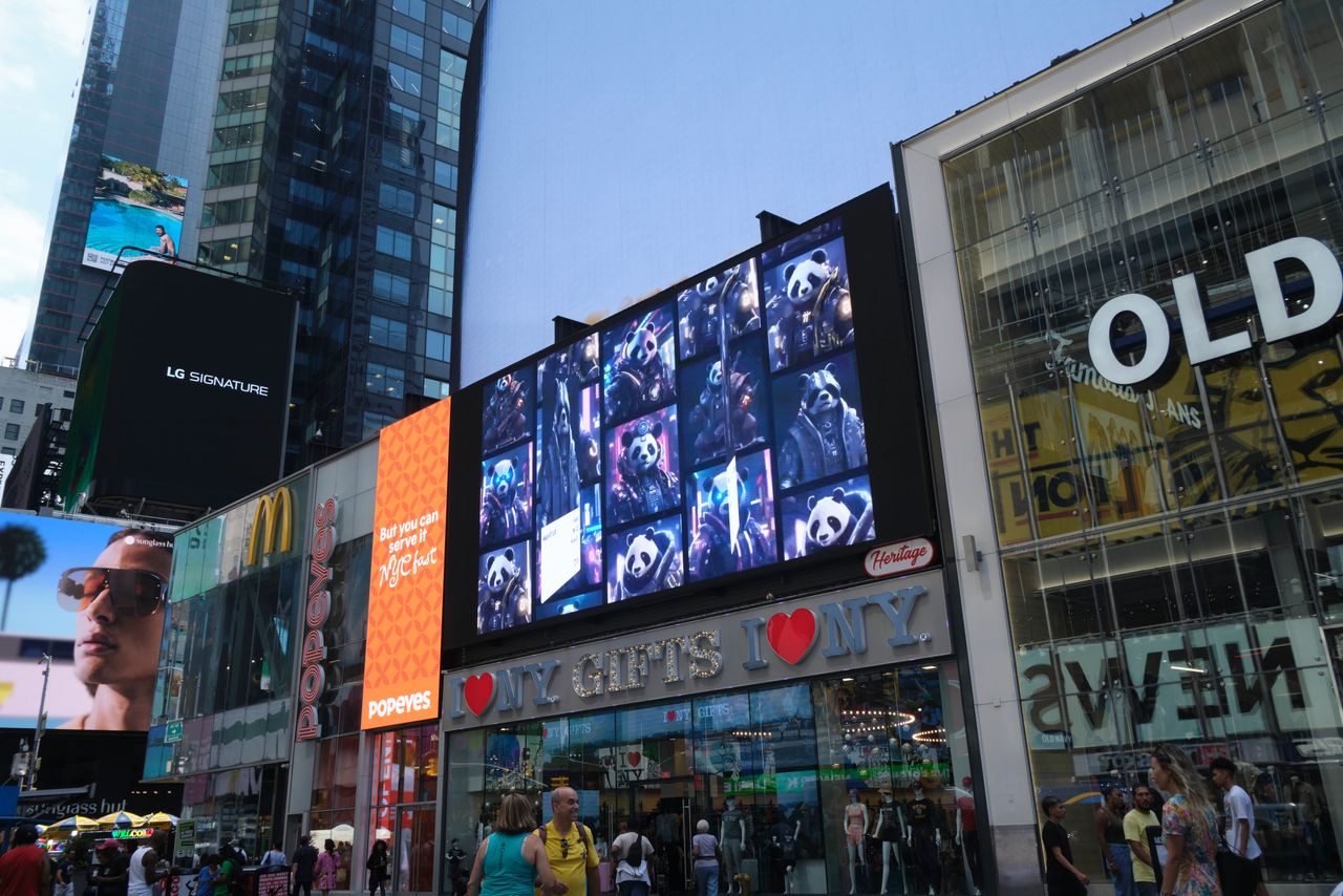 Digital billboard in Times Square displaying vibrant images of animated panda characters, surrounded by retail stores and other advertisements, illustrating the impact of digital out-of-home advertising.
