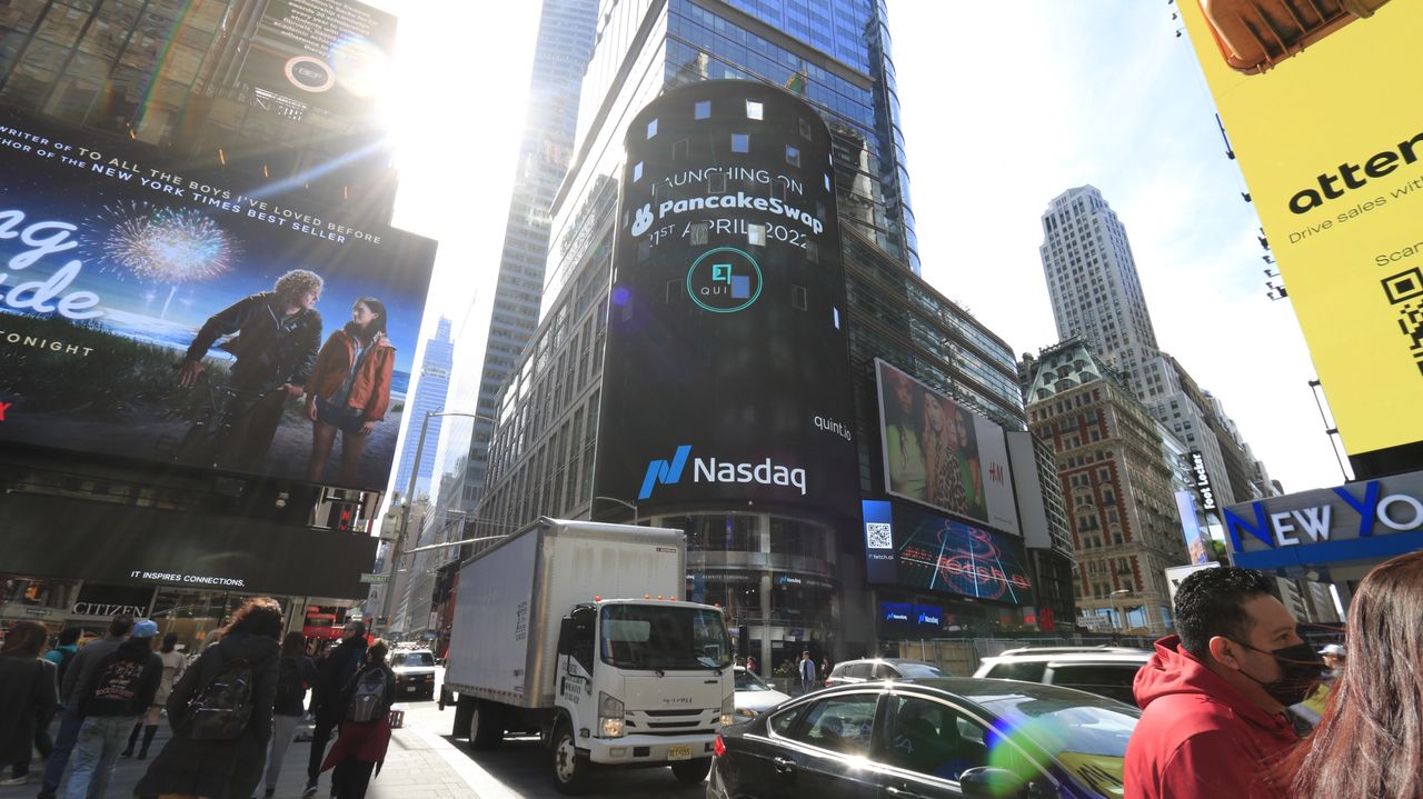 Dazzling electronic billboards in Times Square featuring advertisements for PancakeSwap and Nasdaq, surrounded by bustling pedestrians and traffic, illustrating the vibrant advertising landscape.