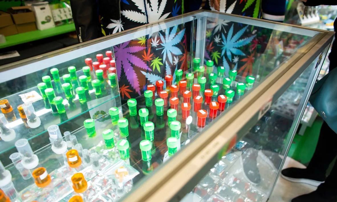 Cannabis product display with various colored containers in a retail setting, highlighting the cannabis market and compliance with New York regulations.
